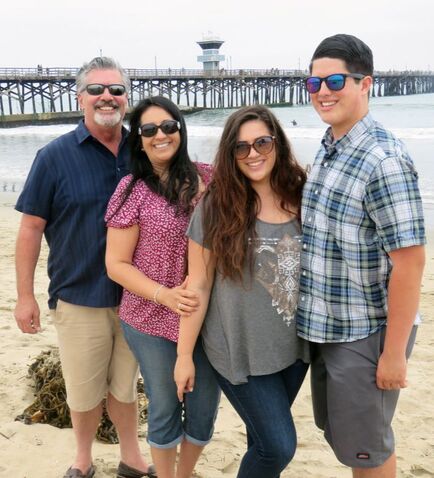 Picture of Sparks family smiling on the beach at Seal Beach Pier