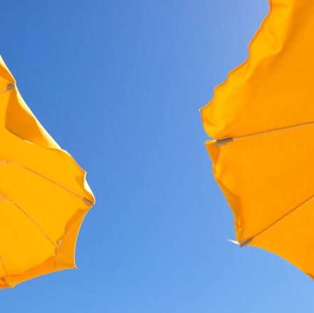 Picture of two yellow umbrellas with a blue sky